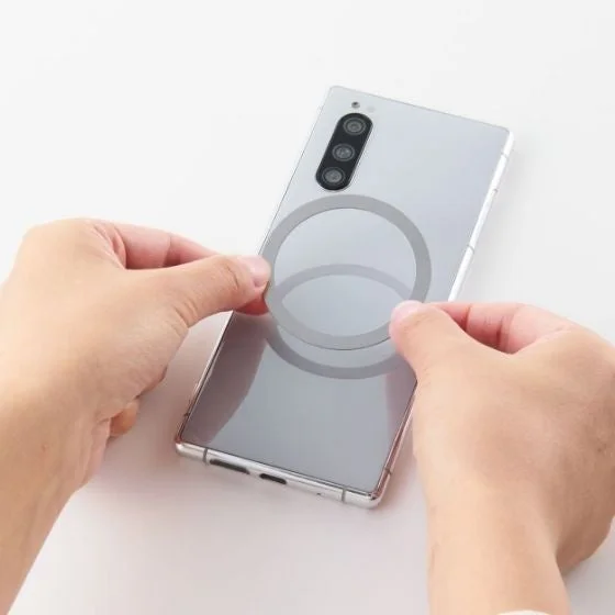 スマホ背面にメタルプレートを貼り付ける様子