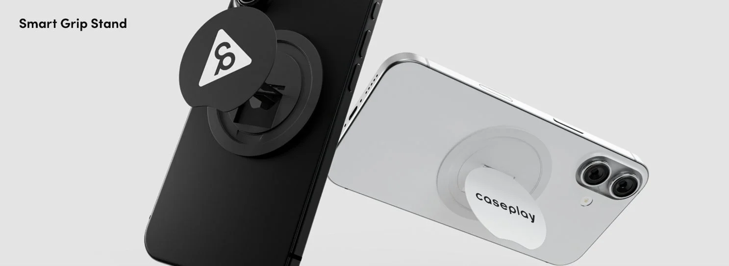 黒と白のスマートフォンに、それぞれ異なる色の「Smart Grip Stand」が装着されている様子を写した画像