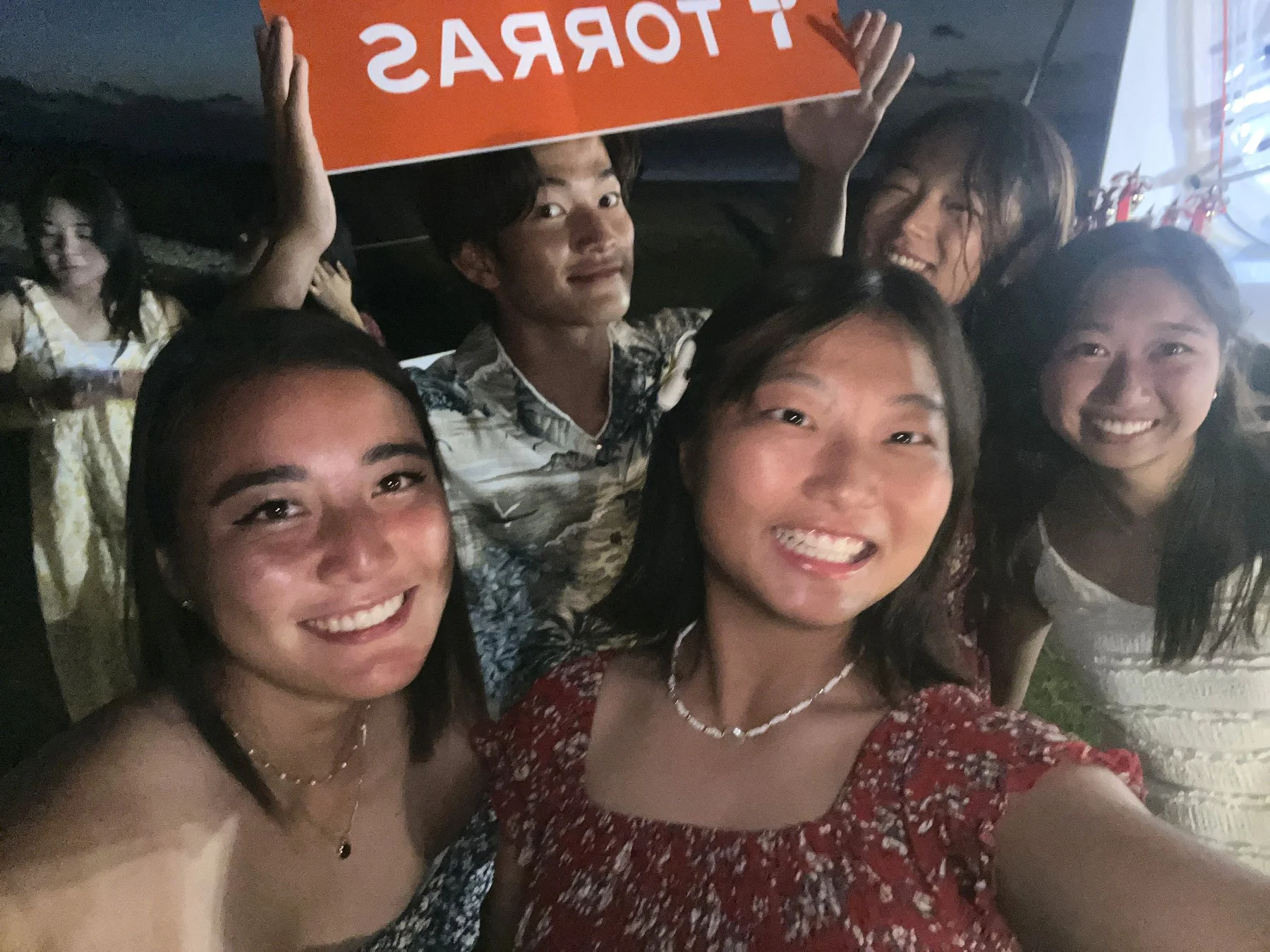 TORRASの看板と若者のグループ写真