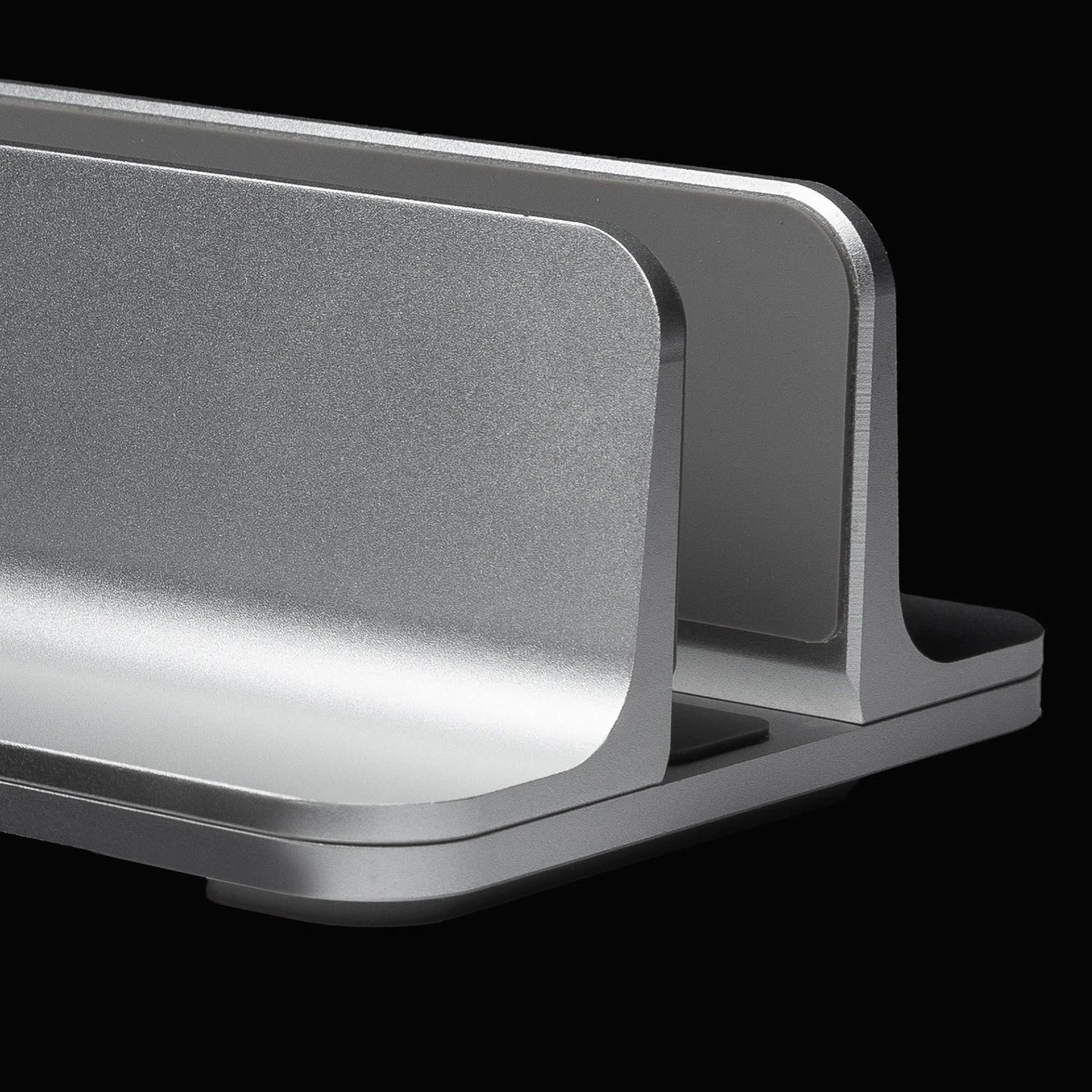 黒い背景に置かれた銀色の金属製ラップトップスタンド