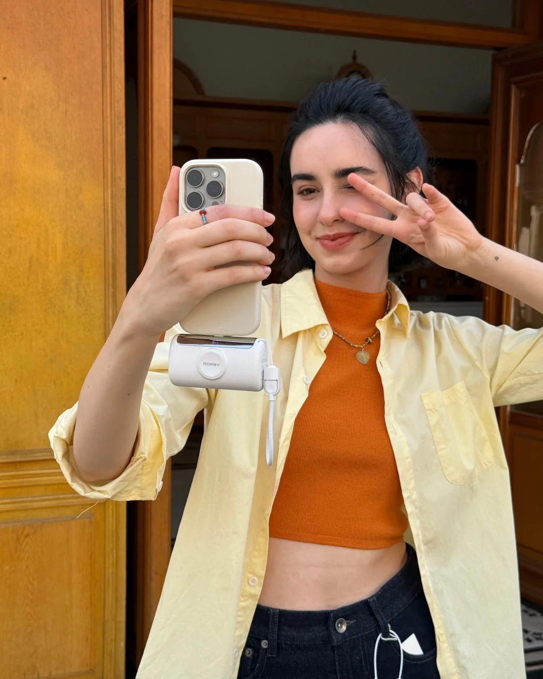 ピースサインをする女性がスマートフォンで自撮り