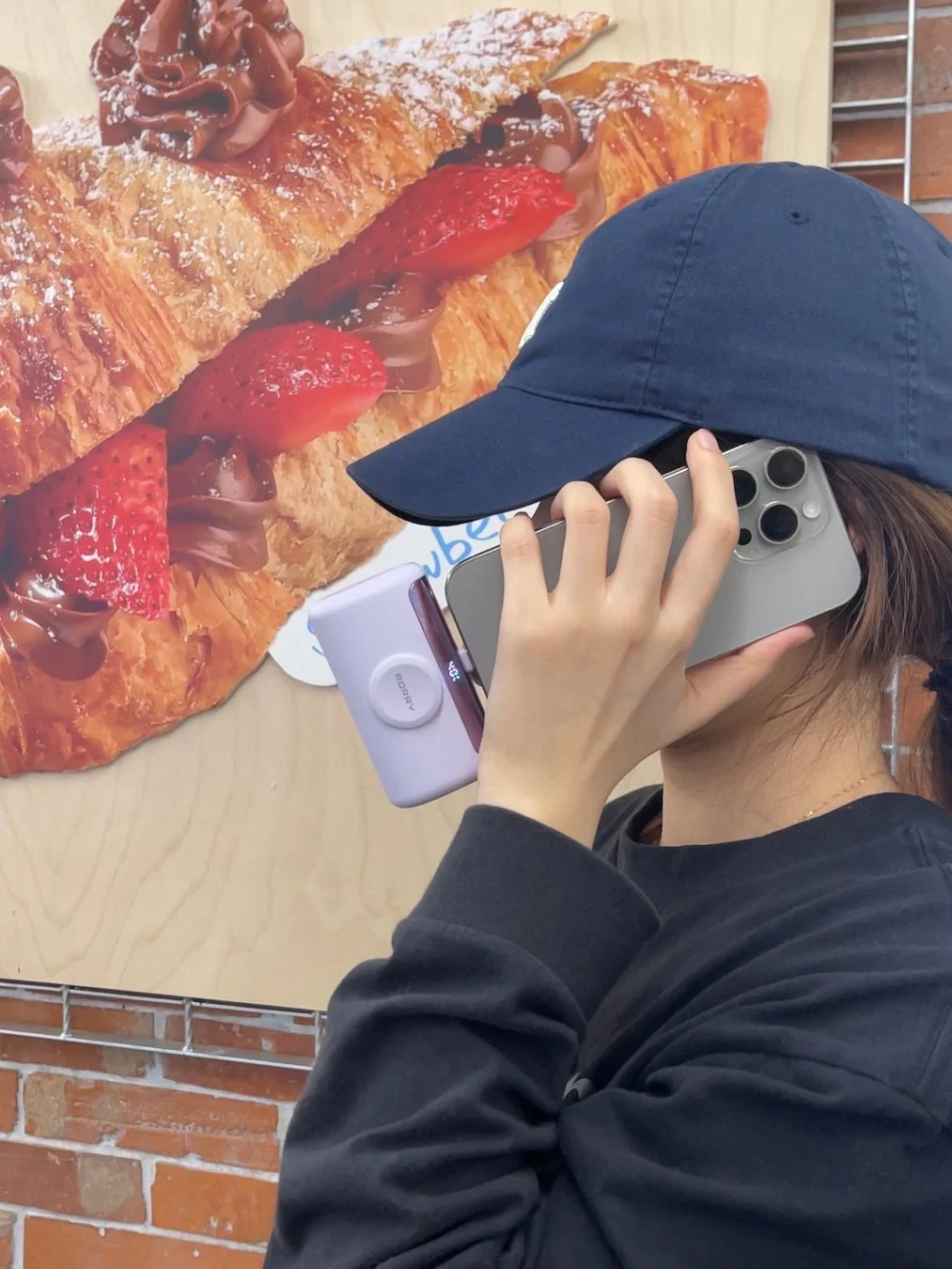 カフェでスマートフォンを操作する人物